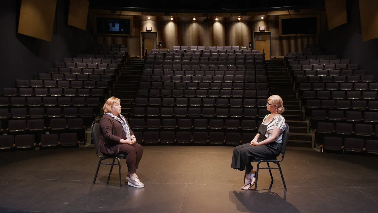Interview frame from the ArtsCO Art Is What You Make of It artist series inside a theatre.