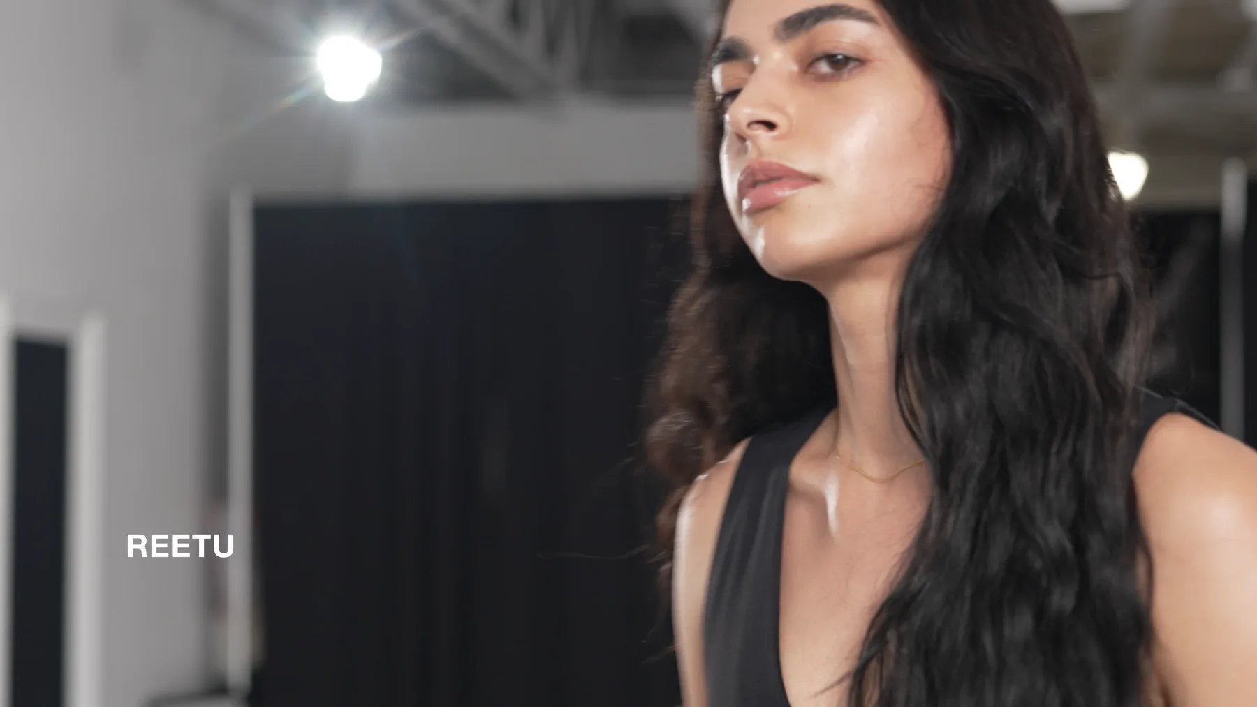 Reetu in casual clothing with her name on screen during the Deja Vu Model Search.