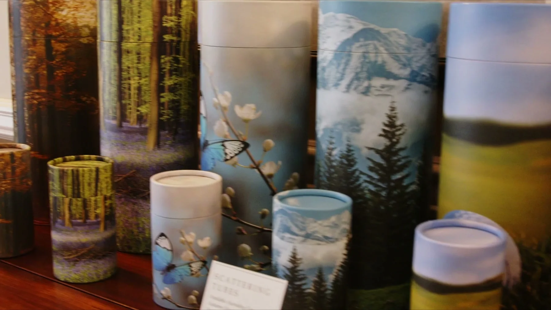 Decorative urns and keepsake vessels stand together on a display.