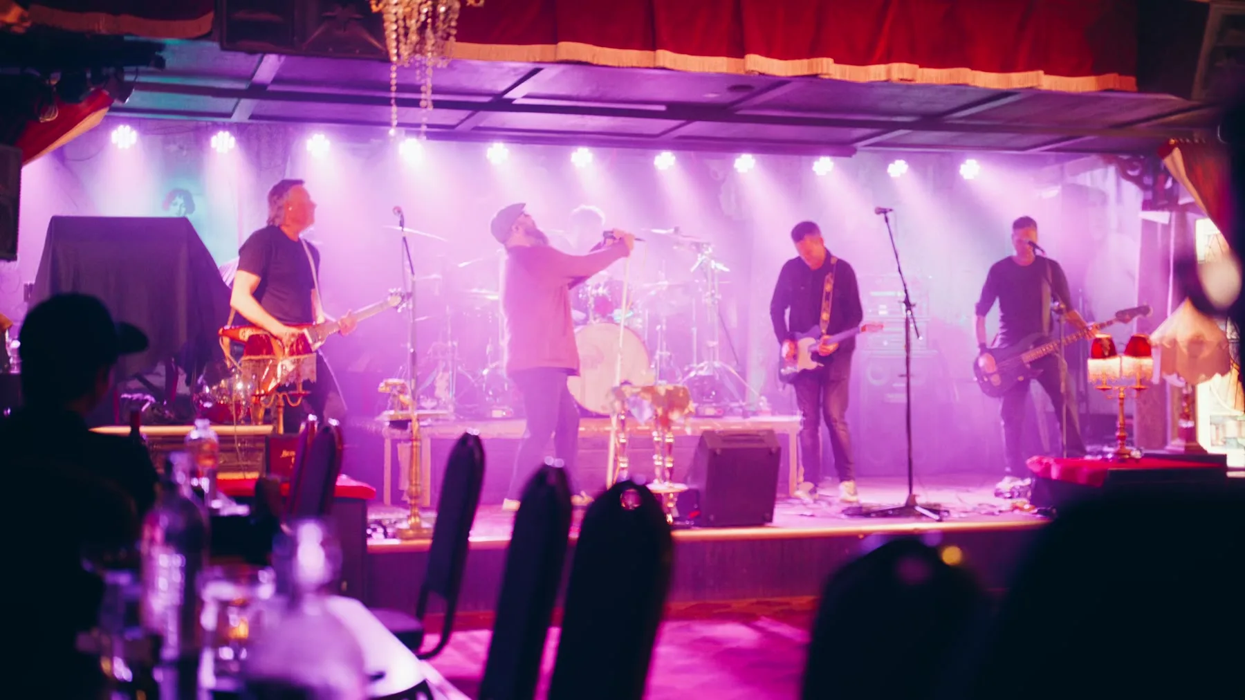 Live music stage in pink and purple light from the Jason Parkes Customs commercial.