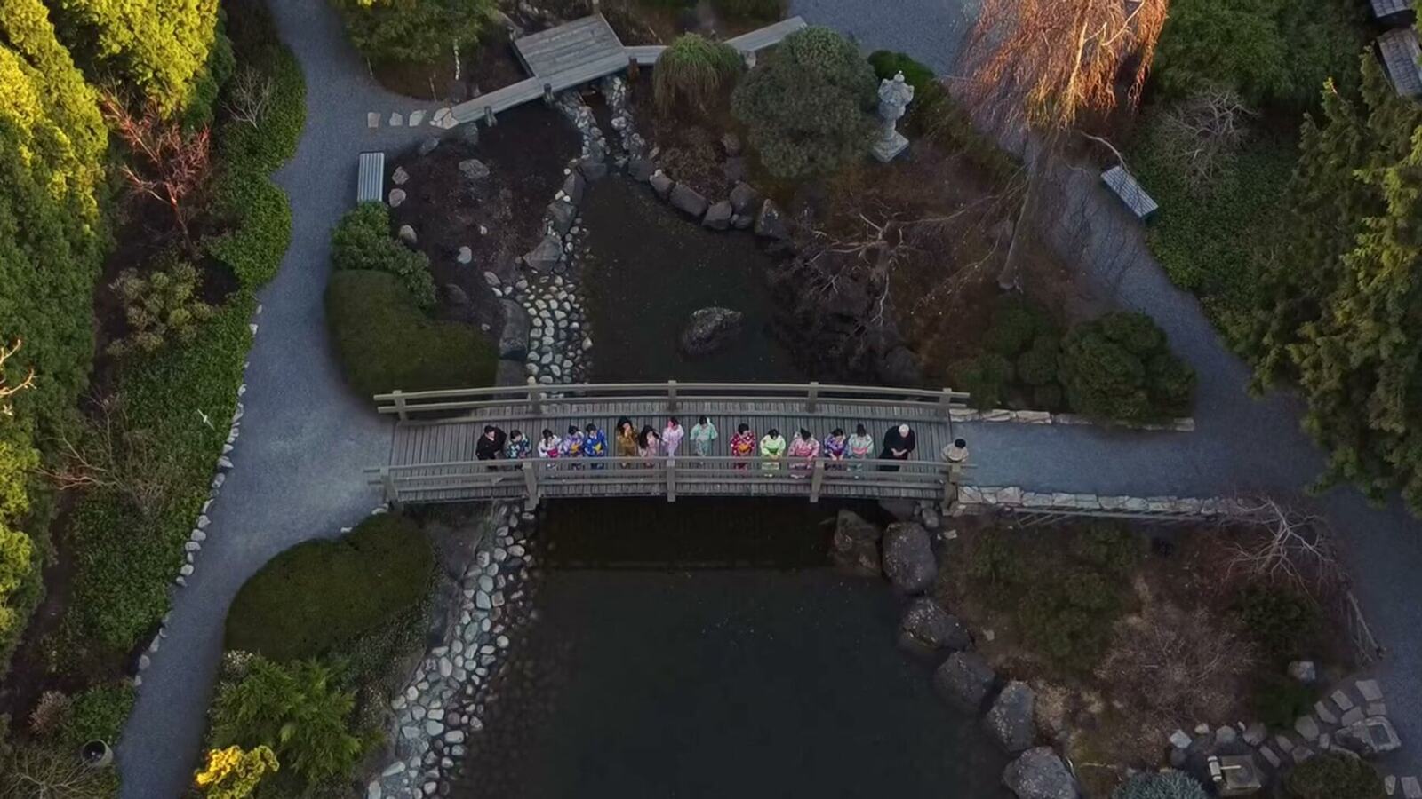 An aerial view of delegates gathered on a bridge in Kasugai Gardens, Kelowna.