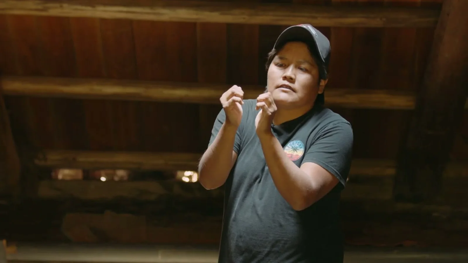 Laureen Felix demonstrates Splatsin traditional fishing practices inside a wood teaching shelter.