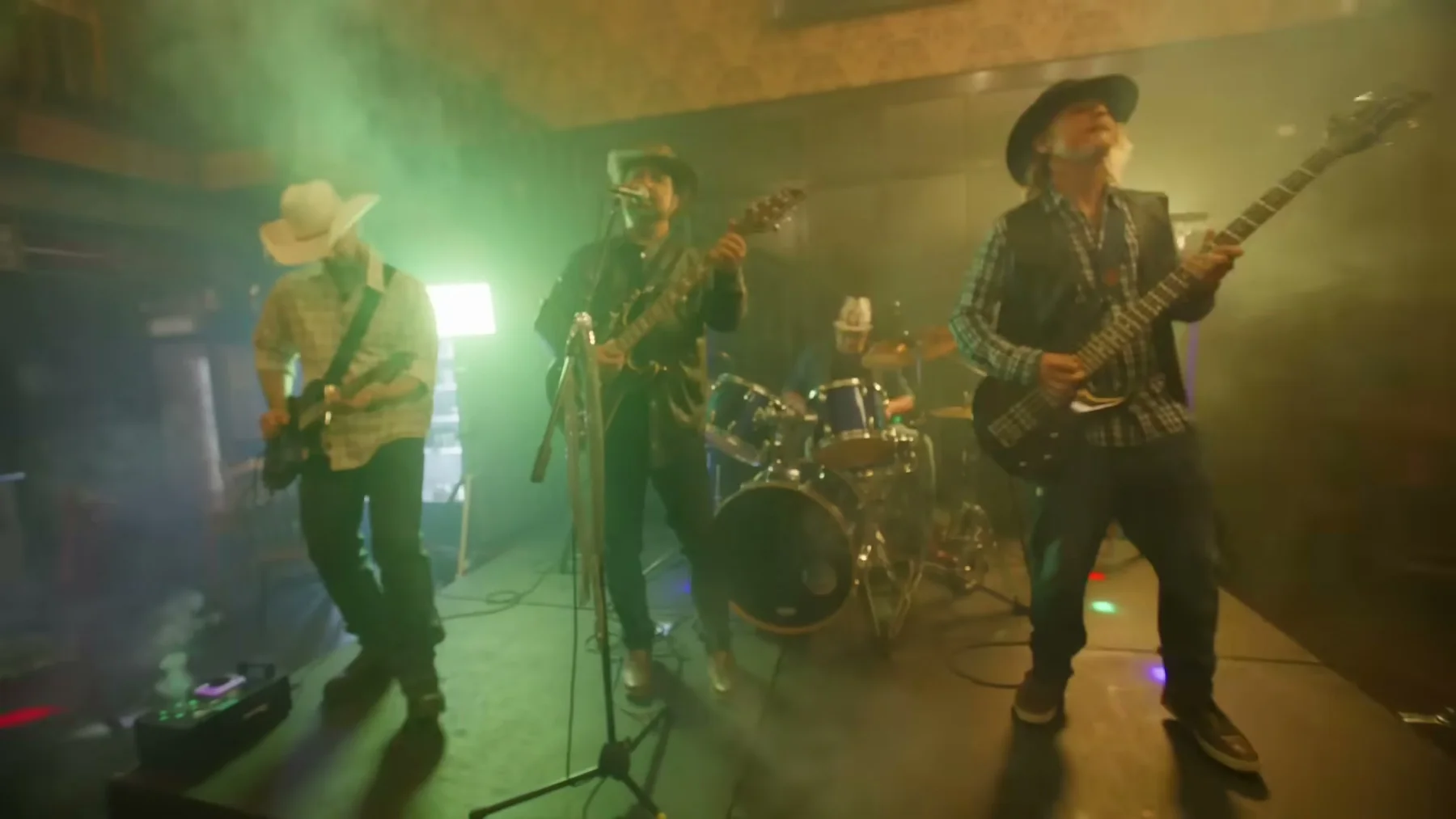 Kris Anders and his band perform under green and amber light in Open Road.