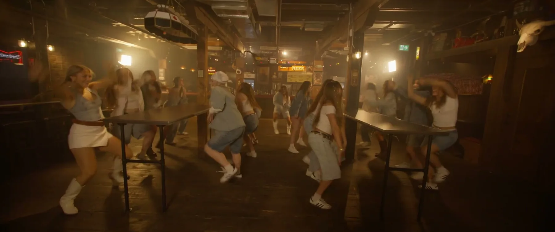 Sockeye 2025 ensemble dances in rows under warm industrial lights.