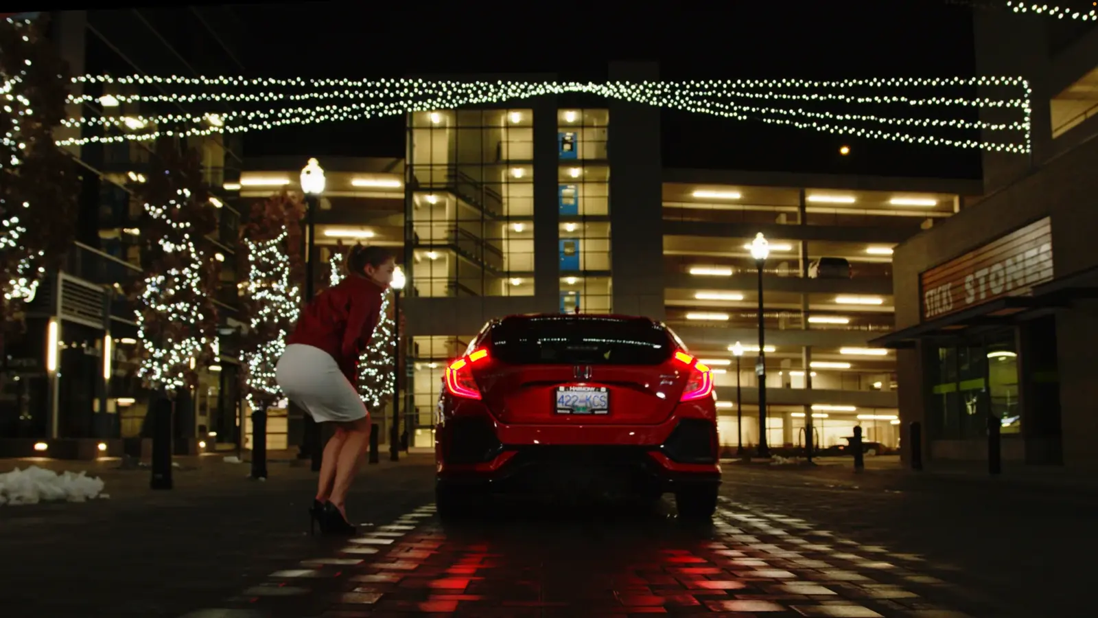 Night exterior frame from The Gift showing an actor's legs beside a car.