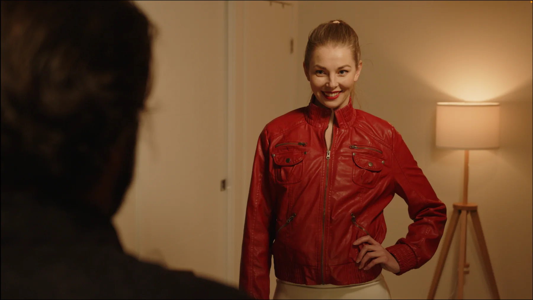 Interior frame from The Gift with Dan Marcelino looking toward the actor in the red jacket.