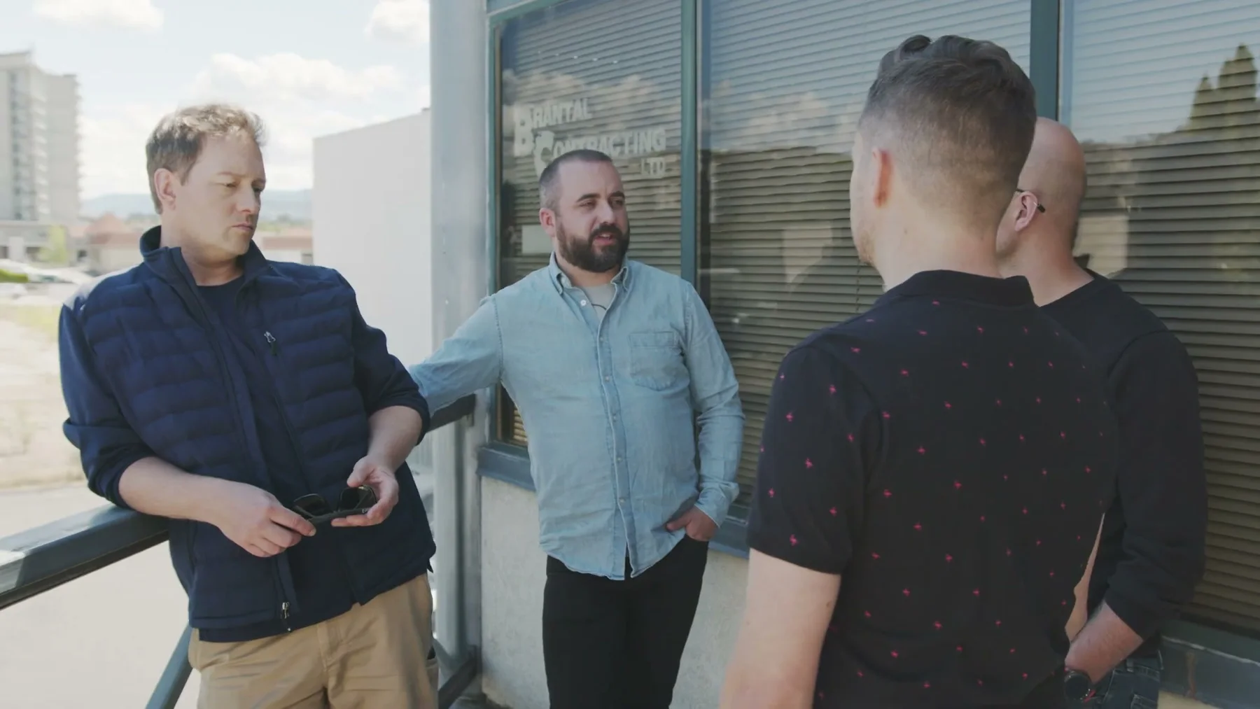 Three Gneiss Stuff team members talk outside the office.