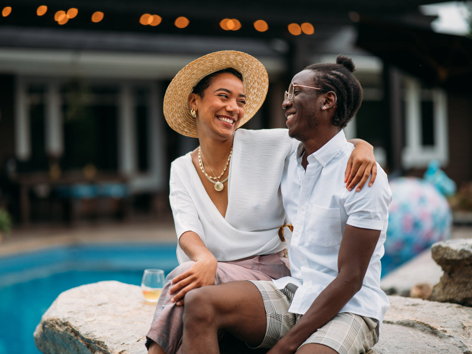Two Zeff models laugh together beside the pool in lifestyle campaign photography.